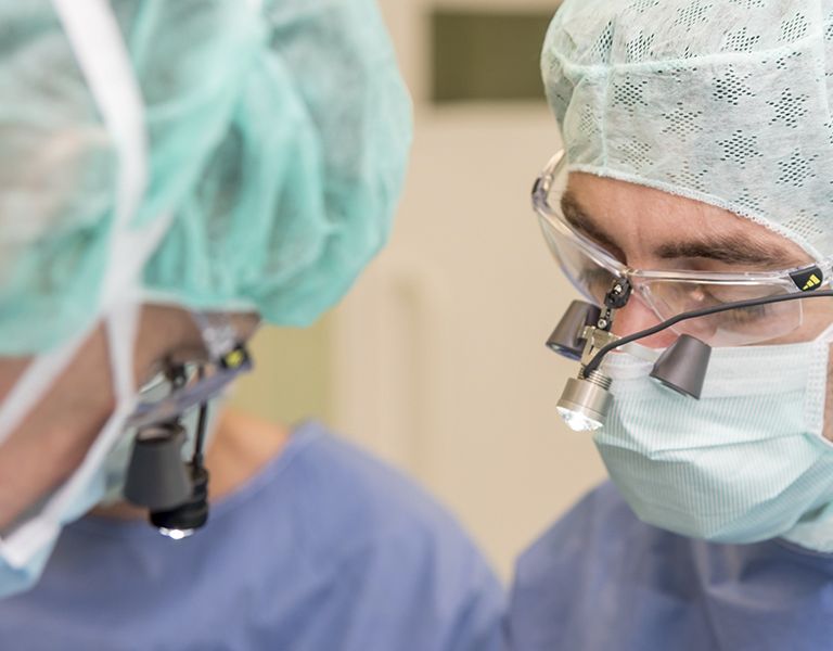 Das Bild zeigt zwei Ärzte bei einer Operation HNO